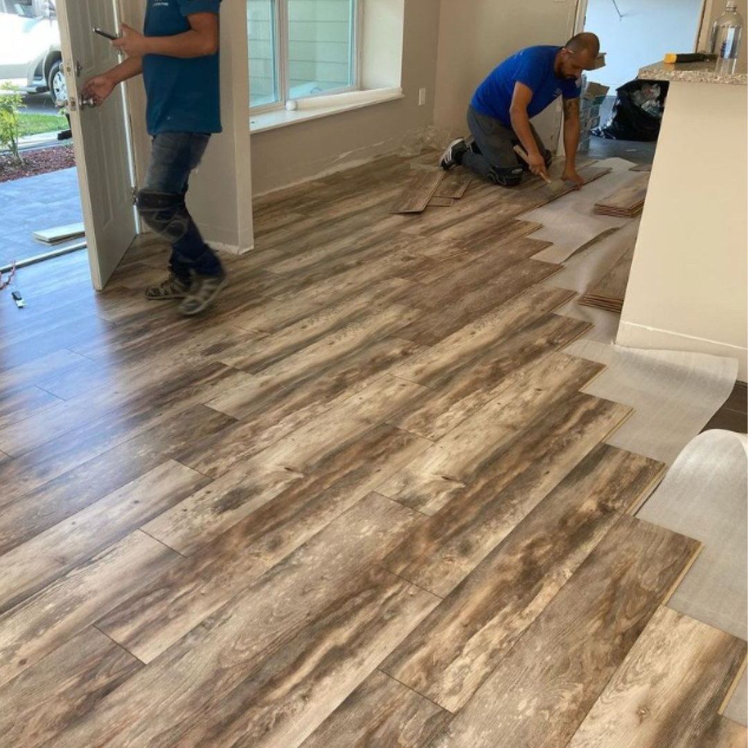 BPS crew installing wood-look vinyl plank flooring during a home remodel