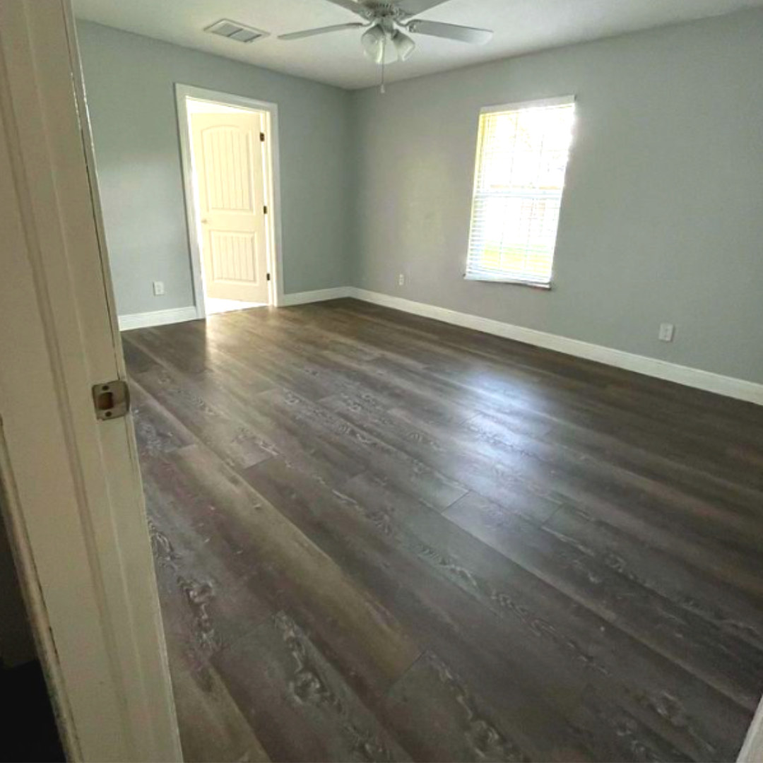Dark grey vinyl plank flooring in a bright, modern bedroom