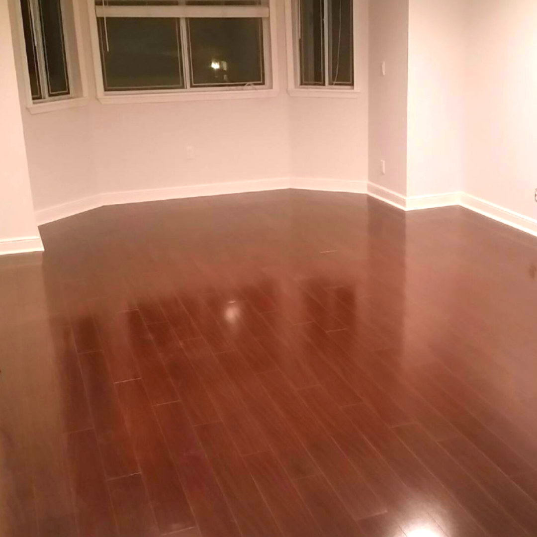 Glossy cherry hardwood flooring in a bright bay-window room