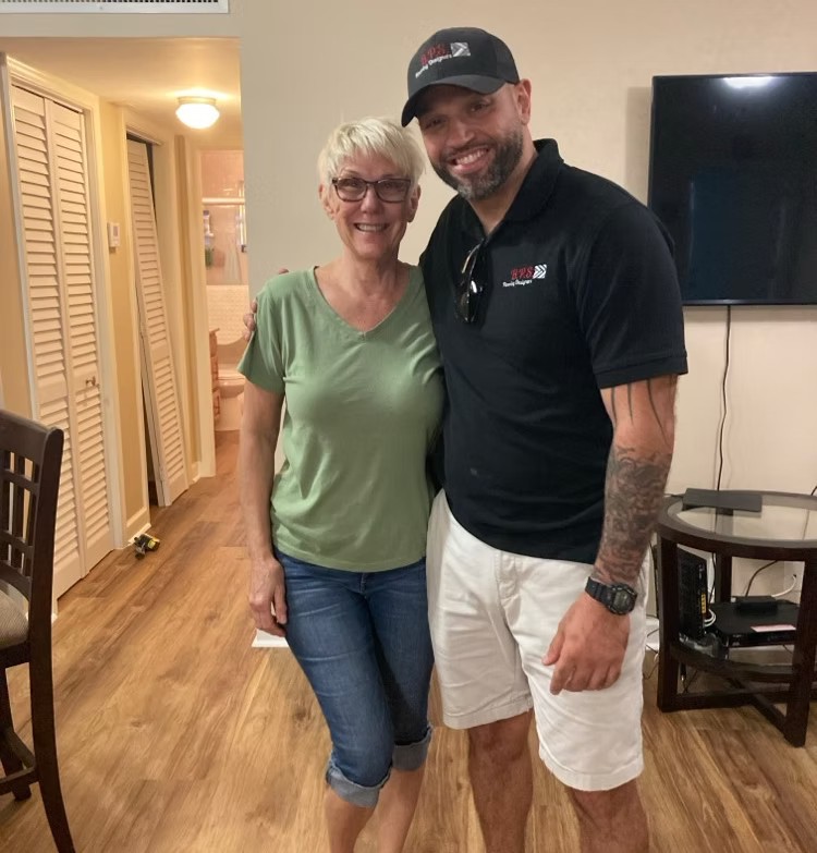 Founder Eddie Baeza with a happy customer in her newly floored home